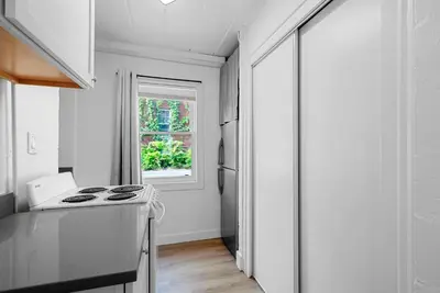 a white kitchen with a stove and a window at Chic City Retreat 93A in Columbus
