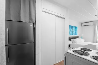 a kitchen with a refrigerator and a bed in a room at Chic City Retreat 93A in Columbus