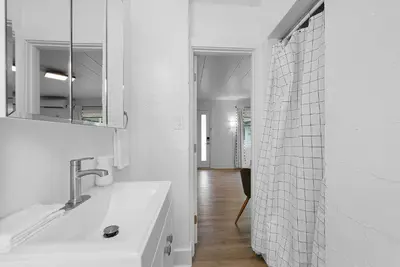 a white bathroom with a sink and a mirror at Chic City Retreat 93B in Columbus