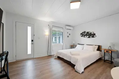 a white bedroom with a large bed and a table at Chic City Retreat 93B in Columbus