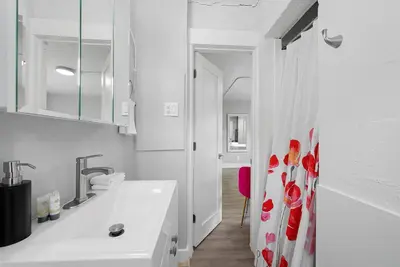 a white bathroom with a sink and a shower curtain at Chic City Retreat 93D in Columbus