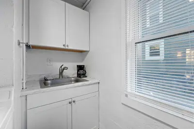 a white kitchen with a sink and a window at Chic City Retreat 93E in Columbus