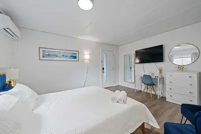 a white bedroom with a white bed and a tv at Chic City Retreat 93G in Columbus