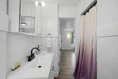 a bathroom with a sink and a pink shower curtain at Chic City Retreat 93H in Columbus