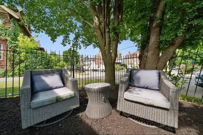 two wicker chairs and a table in front of a tree at Chic City Retreat 93H in Columbus