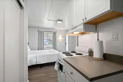 a kitchen with a stove top oven next to a bedroom at Chic City Retreat 97 in Columbus