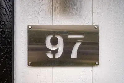 a metal sign on a wall with the number at Chic City Retreat 97 in Columbus