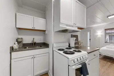 a white kitchen with a stove and a sink at Chic City Retreat 93J For 2 in Columbus