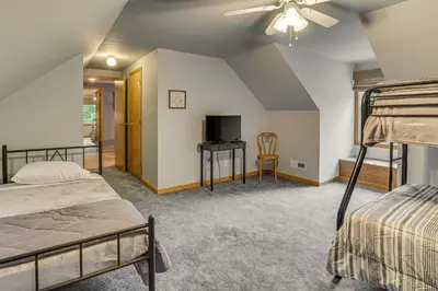 a bedroom with two bunk beds and a tv at 2 Mi to Woodbury Wildlife Area Cozy Farmhouse! in Warsaw