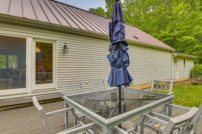 an umbrella sitting on a table in front of a house at 2 Mi to Woodbury Wildlife Area Cozy Farmhouse! in Warsaw