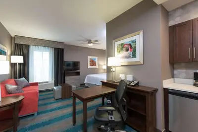a hotel room with a desk and a bed at Homewood Suites by Hilton Cleveland/Sheffield in Avon