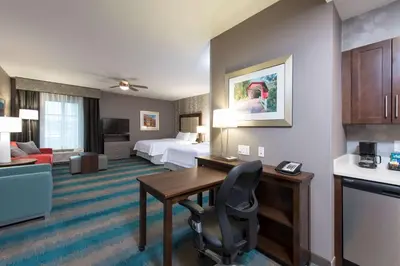 a hotel room with a desk and a bed at Homewood Suites by Hilton Cleveland/Sheffield in Avon
