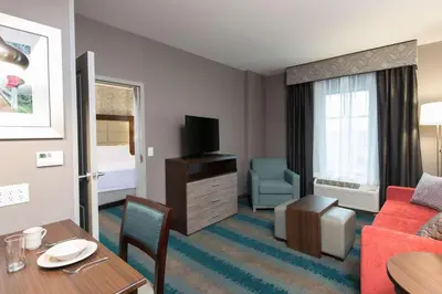 a living room with a red couch and a table at Homewood Suites by Hilton Cleveland/Sheffield in Avon