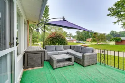 a patio with a couch and an umbrella on a house at 3 Mi to Pro Football Hall of Fame Home with Yard! in Canton