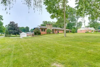 a large yard with a house and a tree at 3 Mi to Pro Football Hall of Fame Home with Yard! in Canton