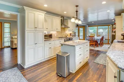a kitchen with white cabinets and a dining room at 3 Mi to Pro Football Hall of Fame Home with Yard! in Canton