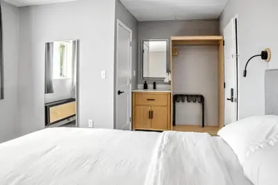 a white bedroom with a white bed and a bathroom at The Mulberry in Logan