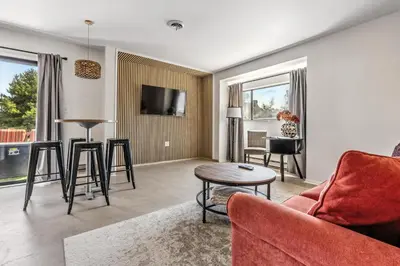 a living room with a red couch and a table at The Mulberry in Logan