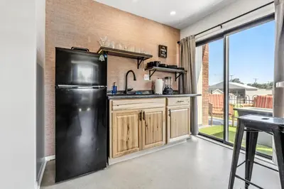 a kitchen with a black refrigerator and wooden cabinets at The Mulberry in Logan