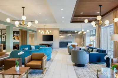a lobby with blue couches and chairs and a television at TownePlace Suites Dayton Beavercreek in Beavercreek