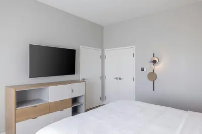 a white bedroom with a tv and a bed at TownePlace Suites Dayton Beavercreek in Beavercreek