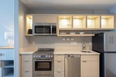 a kitchen with stainless steel appliances and wooden cabinets at TownePlace Suites Dayton Beavercreek in Beavercreek
