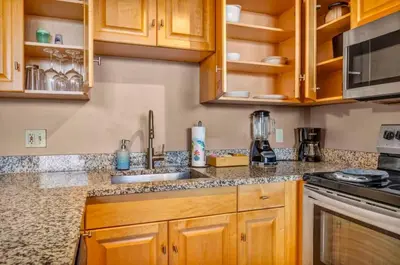 a kitchen with wooden cabinets and granite counter tops at 1Br in Heart of Downtown, Sauna, Prime Location in Cleveland
