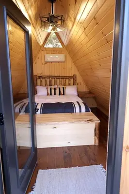 a bedroom with a bed in a wooden cabin at Secluded A-Frame Incredible for Water Activities by Tappan Lake in Ohio in Deersville