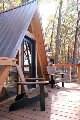 a small cabin with two benches on a deck at Secluded A-Frame Incredible for Water Activities by Tappan Lake in Ohio in Deersville