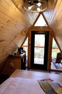 a room with a bed and a window in a cabin at Amazing A-Frame by Tappan Lake Perfect for Outdoor Lovers in Ohio in Deersville