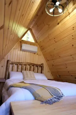 a bedroom with two beds in a wooden cabin at Amazing A-Frame by Tappan Lake Perfect for Outdoor Lovers in Ohio in Deersville