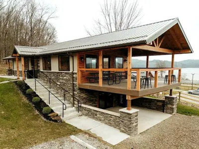 a house with a deck with tables and chairs at Group Friendly Cabin with Spa on the Deck near Tappan Lake in Ohio in Deersville