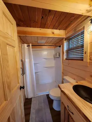 a small bathroom with a toilet and a sink at Group Friendly Cabin with Spa on the Deck near Tappan Lake in Ohio in Deersville