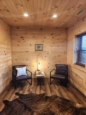 a room with two chairs and a table in a log cabin at Group Friendly Cabin with Spa on the Deck near Tappan Lake in Ohio in Deersville