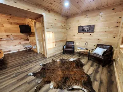 a room with a large tree stump in the middle of a cabin at Lakeview Cabin by Tappan Lake, Perfect for Groups with Hot-Tub in Ohio in Deersville