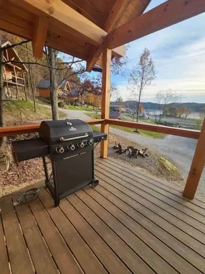 a grill on a deck with a group of dogs at Lakeview Cabin by Tappan Lake, Perfect for Groups with Hot-Tub in Ohio in Deersville