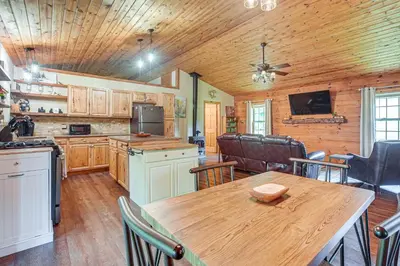 a kitchen and dining room with a wooden ceiling at Pond and Fire Pit Charming Log Cabin near Blue Rock in Blue Rock