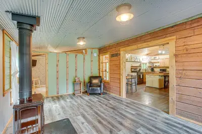 a living room with a woodburning stove in a house at Pond and Fire Pit Charming Log Cabin near Blue Rock in Blue Rock