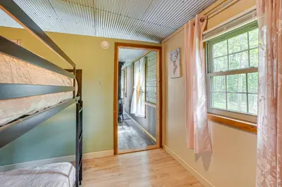 a bedroom with a bunk bed and a window at Pond and Fire Pit Charming Log Cabin near Blue Rock in Blue Rock