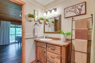 a bathroom with a sink and a mirror at Pond and Fire Pit Charming Log Cabin near Blue Rock in Blue Rock