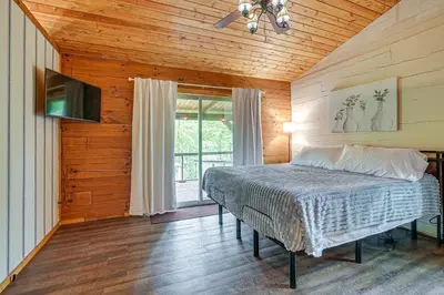 a bedroom with a bed in a room with a window at Pond and Fire Pit Charming Log Cabin near Blue Rock in Blue Rock
