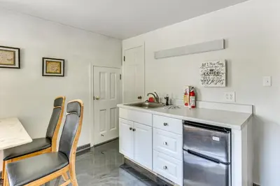 a kitchen with white cabinets and a sink and a table at 1 Mi to Dtwn Salem Apt with Garage Access! in Salem