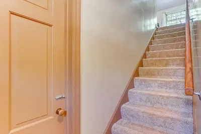 a stairway with a door leading up to a stair case at 1 Mi to Dtwn Salem Apt with Garage Access! in Salem