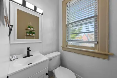 a bathroom with a toilet and a sink and a mirror at Merion Village Residences - Escape the Hustle & Bustle in Columbus