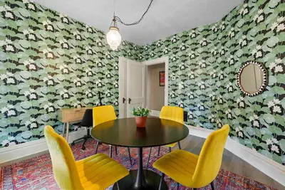 a dining room with a table and yellow chairs at Merion Village Residences - Escape the Hustle & Bustle in Columbus