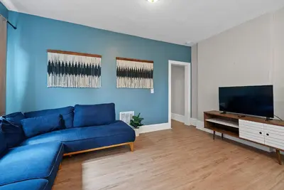 a living room with a blue couch and a flat screen tv at Merion Village Residences - Peaceful Columbus Neighborhood in Columbus