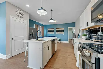 a large kitchen with blue walls and a sink at Merion Village Residences - Peaceful Columbus Neighborhood in Columbus