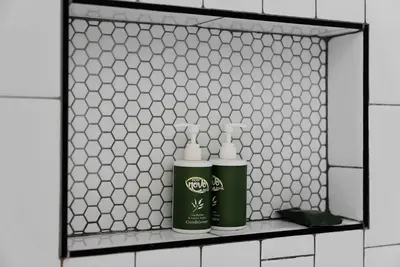 two bottles ofodorizers on a shelf in a bathroom at Merion Village Residences - Peaceful Columbus Neighborhood in Columbus