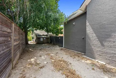 an empty driveway next to a building with a fence at CGV - Unique and Memorable 3BDR Stay in Columbus