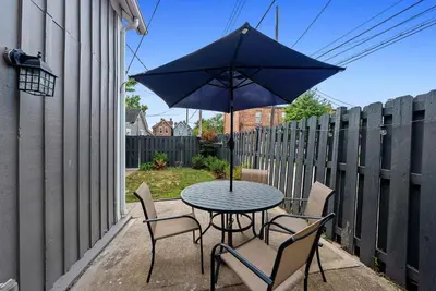 a table and chairs with an umbrella on a patio at CGV - Unique and Memorable 3BDR Stay in Columbus
